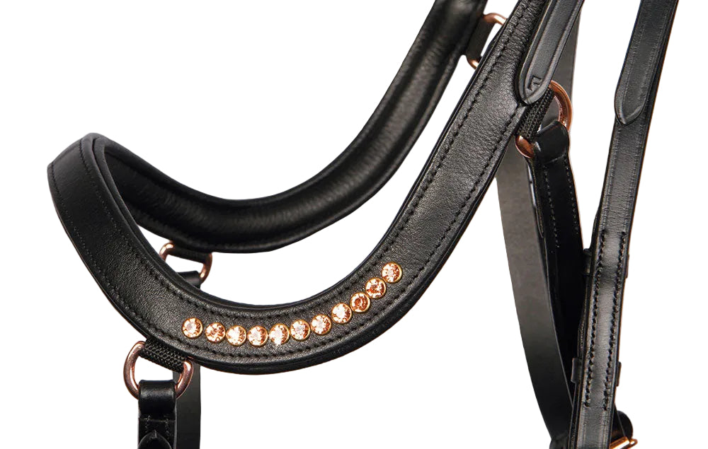 Detailansicht des anatomisch geschnittenen Nasenriemens der Harry’s Horse Trense Rosegold Anatomic – weich gepolstert, druckentlastend und nervenschonend für empfindliche Pferde. Glitzernde rosegoldene Strasssteine sind auf beiden Seiten des anatomischen Nasenriemens angebracht. Für einen besonders funkelnden Auftritt. Sehr auffällig am Pferdekopf.