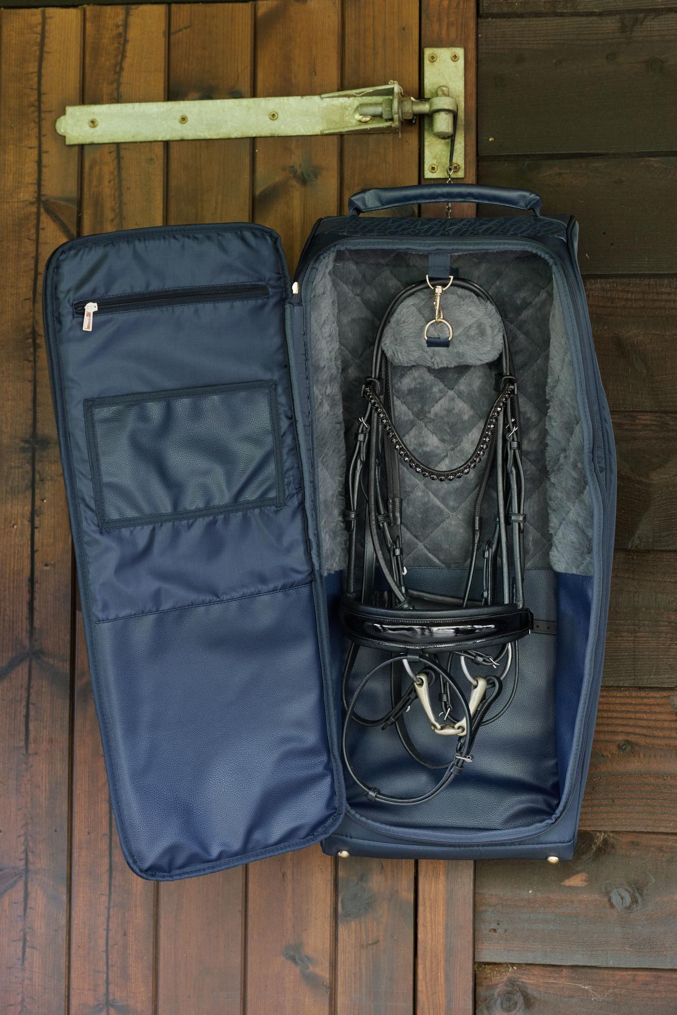 LeMieux Luxe Trensentasche Navy hängt vor Pferdebox – luxuriöse Trensentasche gefüllt mit edler Trense, hochwertiges Reitsport Zubehör für Turnier & Stall, schützt Zaumzeug stilvoll, Teil der exklusiven LeMieux Luxe Serie in Navy Blau.