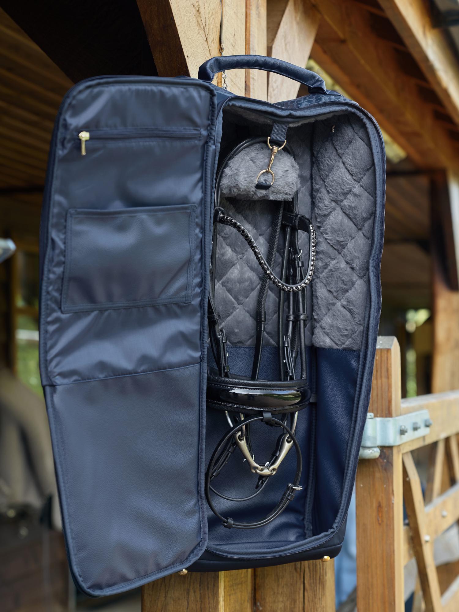 LeMieux Luxe Trensentasche Navy hängt draußen vor Stall – gefüllt mit hochwertiger Trense, elegante Reitsport Aufbewahrungstasche für Trense & Kandare, wetterfestes Design in edlem Navy Blau, perfekter Look für Turnier, Training & Transport.