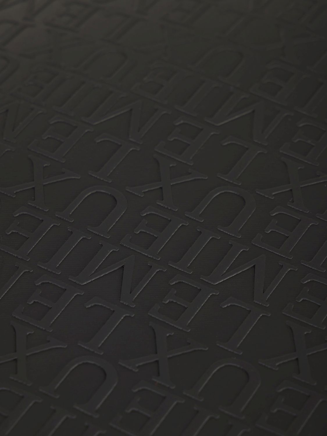 Detailaufnahme der LeMieux Helmtasche Luxe Schwarz mit edlem Allover Print auf der Vorderseite – luxuriöse Reithelm Tasche mit Markenprägung.
