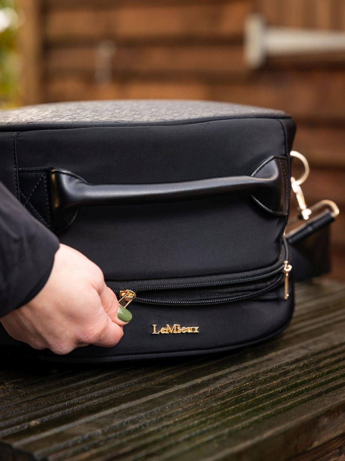 LeMieux Helmtasche Luxe Schwarz mit goldenen Metallbeschlägen und edlem LeMieux Logo – luxuriöses Design für Reitsport.