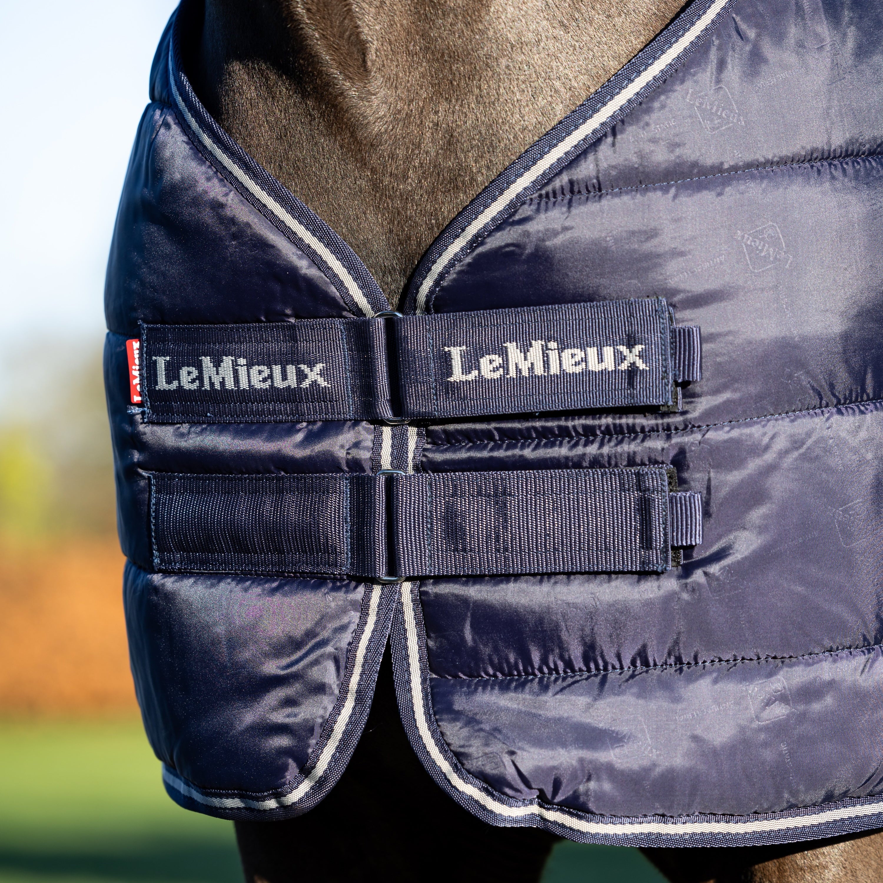 Detailaufnahme des Brustverschlusses mit Klettverschluss an der LeMieux Unterdecke 200 g Navy. Der pferdefreundliche Verschluss stört nicht beim Liegen oder Wälzen und hält die Decke sicher in Position. Ideal als Liner-System mit einer zweiten Linerdecke, die nahtlos befestigt werden kann, für maximalen Komfort und extra Wärme.
