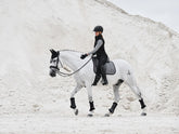 Pferd mit LeMieux Aspen Dressage Square Herringbone schwarz weiß Schabracke, Reiterin in Aspen Capsule Collection, elegante und funktionale Dressurausrüstung.