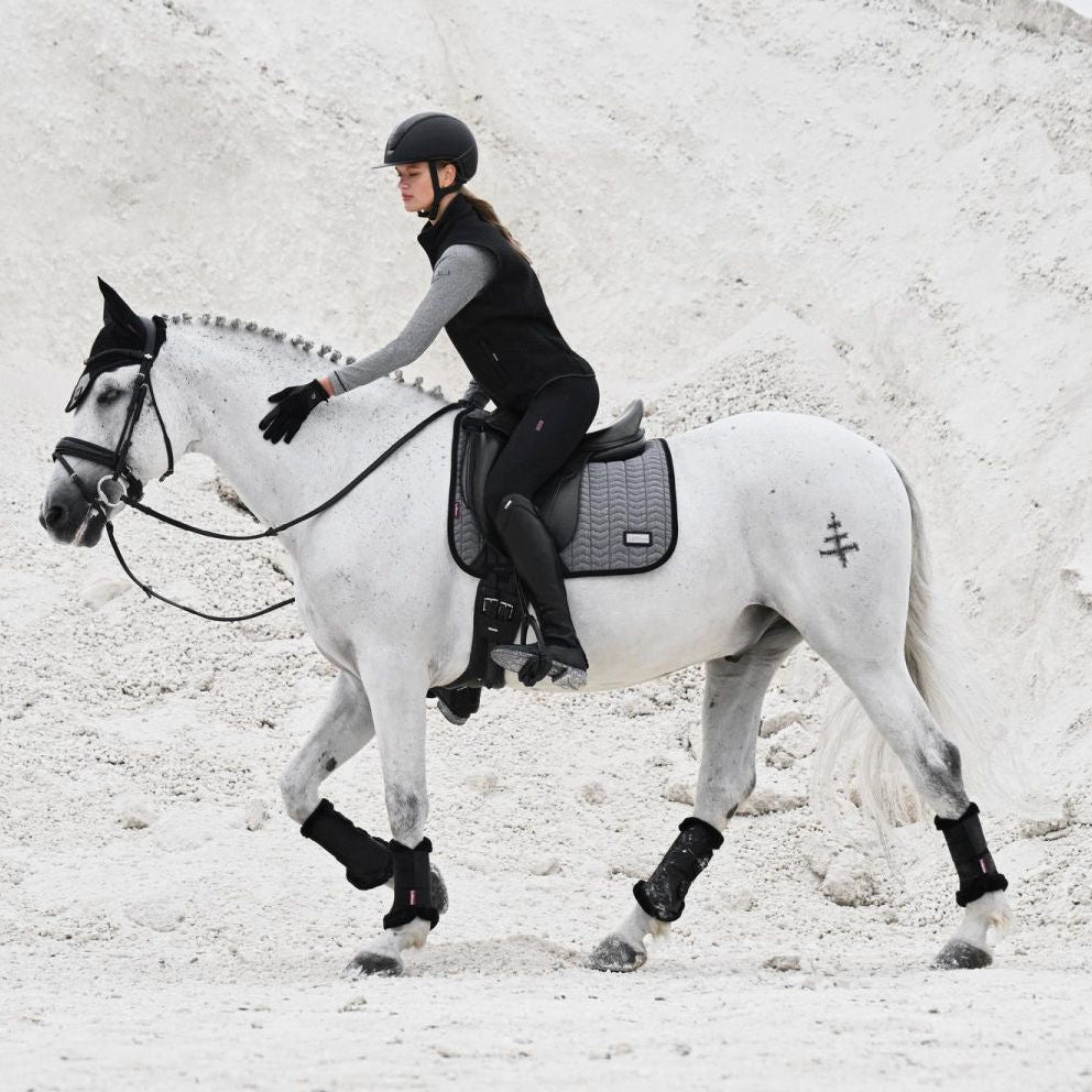 Reiterin und Pferd im eleganten Partnerlook mit LeMieux Aspen Dressage Square Herringbone schwarz weiß Schabracke, modische Capsule Collection, stilvolle Dressurausrüstung.