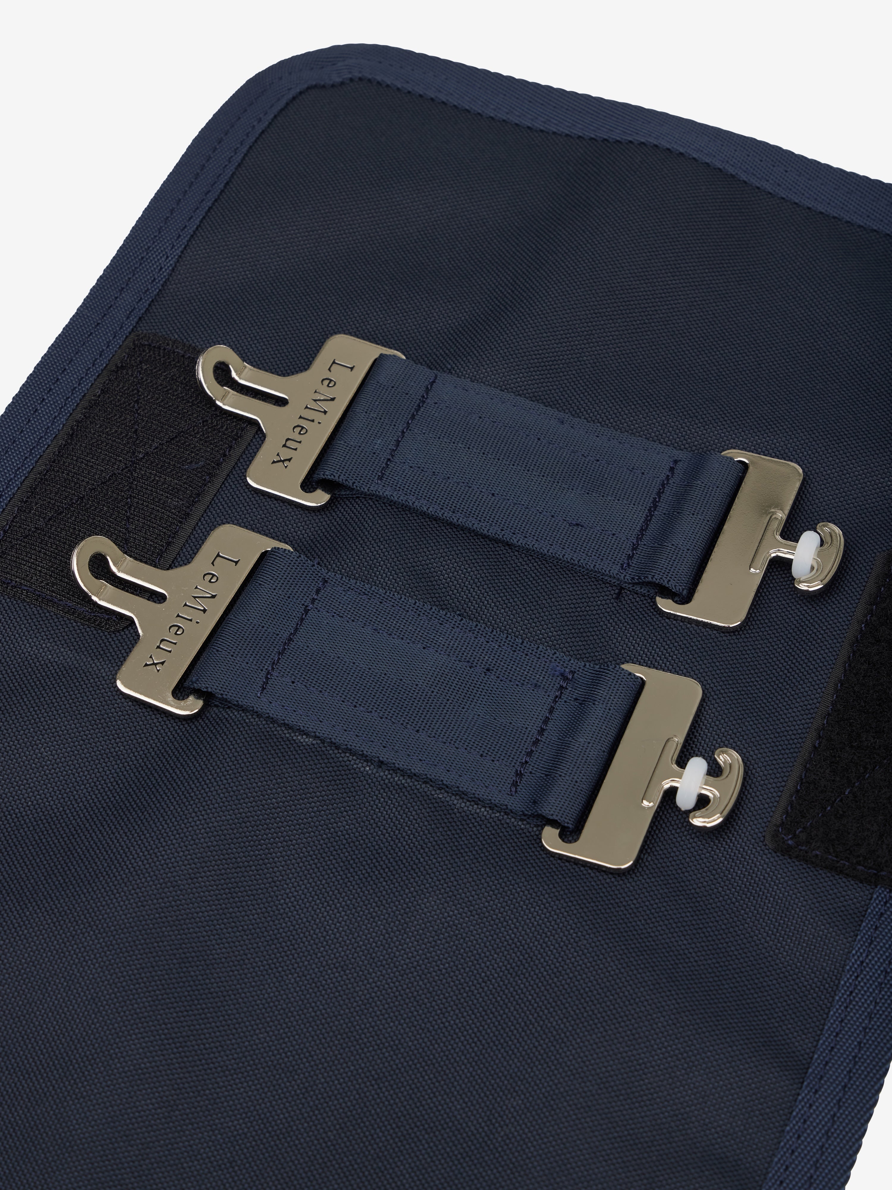 Detailaufnahme der T-Verschlüsse und Klettverschlüsse auf der Vorderseite der LeMieux Brusterweiterung in Navy – für sicheren Halt und perfekte Passform bei Pferdedecken.