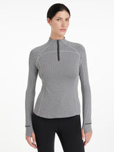 LeMieux Aspen Herringbone Black Base Layer – Damen Reitshirt in Schwarz-Weiß, frontal getragen von Model im Studio. Stehkragen wird hoch geschlossen getragen.