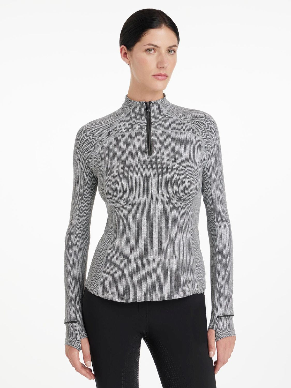 LeMieux Aspen Herringbone Black Base Layer – Damen Reitshirt in Schwarz-Weiß, frontal getragen von Model im Studio. Stehkragen wird hoch geschlossen getragen.