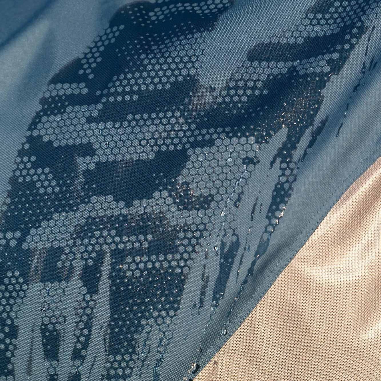 Eine Nahaufnahme der wasserdichten Ripstop-Oberlinie auf dem Pferderücken zeigt die faszinierende Funktion der LeMieux Hybriddecke: An den durch Regen nass gewordenen Stellen erscheint sofort der Camouflage-Print, während die noch trockenen Bereiche einfarbig im Jungle-Ton verbleiben.
