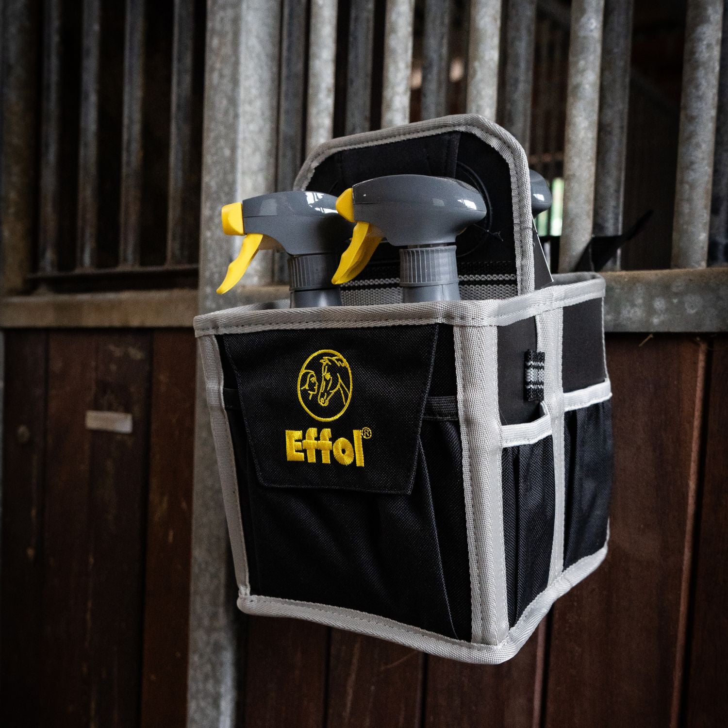 Die handliche Mini-Tote-Bag-Putztasche von Effol kann mit Hilfe von Schlaufen an der Boxentür aufgehängt werden. Hier sieht man, dass die kleine Putztasche mit 4 Fächern an der Boxentür hängt und alle Pferdepflegeutensilien (die wichtigsten) sofort griffbereit sind. Kein Bücken nötig. Diese praktische und effiziente Lösung vereinfacht die Pferdepflege im Alltag.