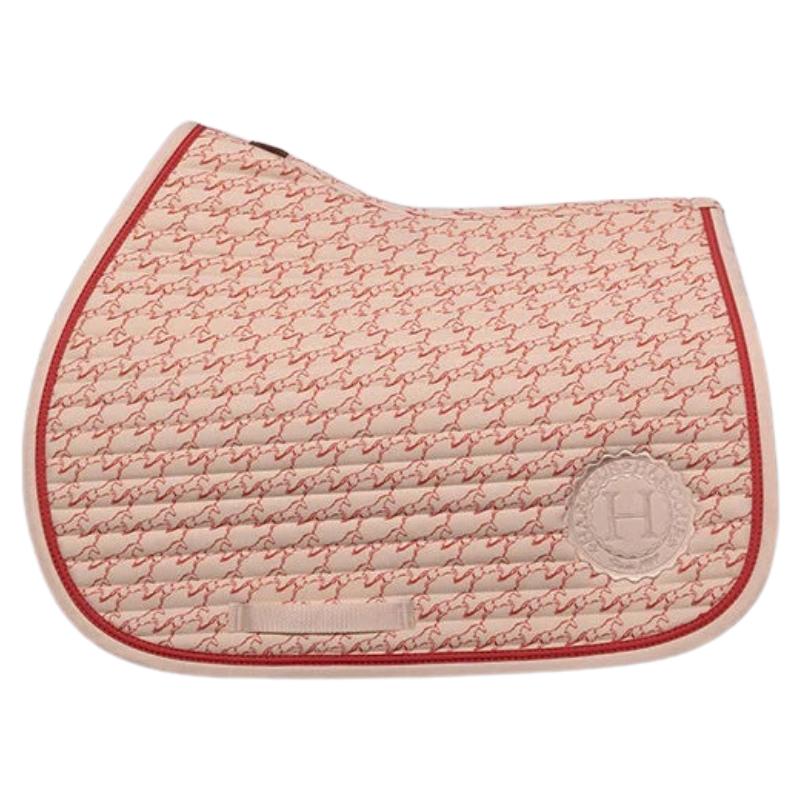 Harcour Springschabracke Karembar Jump Shell Grapefruit. Passt unter moderne Springsättel, klassische Springsättel und Vielseitigkeitssättel. Der Pferdeprint eines springenden Pferdes hebt die Leidenschaft und Dynamik des Springsports hervor.