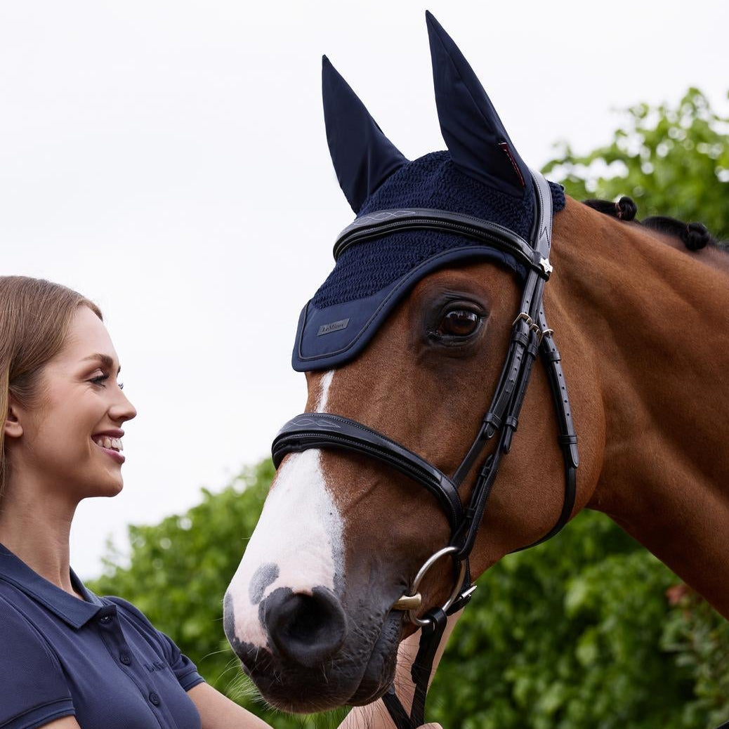 Seitliche Ansicht der LeMieux Fliegenohren Essence Navy am Pferd mit lachender Reiterin – zeigt die perfekte Passform und das flexible Elasthan-Material der Essence Kollektion.