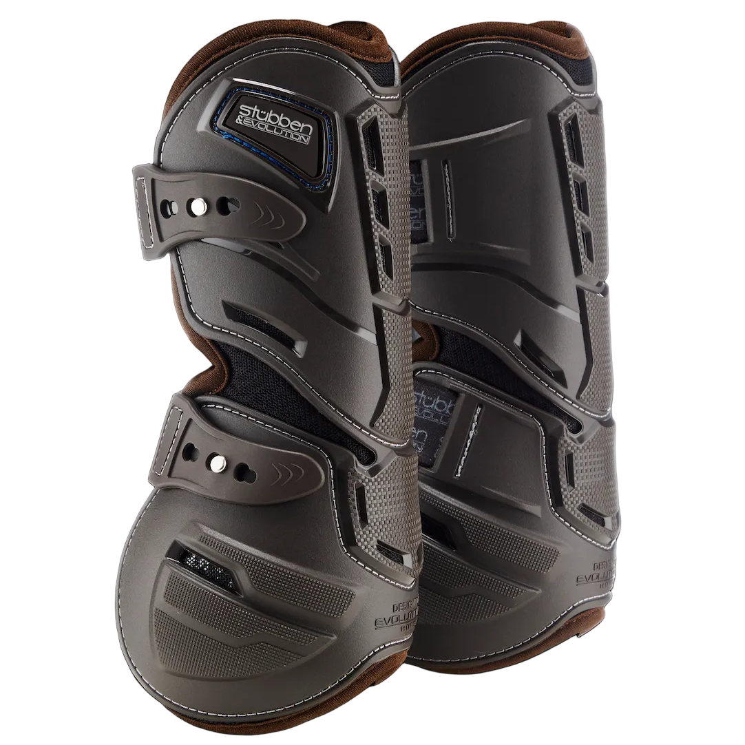 Dieses Paar brauner Stübben Hybrid Springgamaschen für die Vorderbeine zeigt im Detail den verstärkten Schlagschutz im Bereich der Sehnen sowie den an den Seiten vorhandenen innovativen horizontalen Cut-Out-Materialrückschnitt für maximale Flexibilität. Die elastischen Schnellverschlüsse ermöglichen eine einfache Handhabung und einen sicheren Sitz am Pferdebein, während das anatomische Evolution-Design der Hartschalengamasche optimale Bewegungsfreiheit im Springsport garantiert.