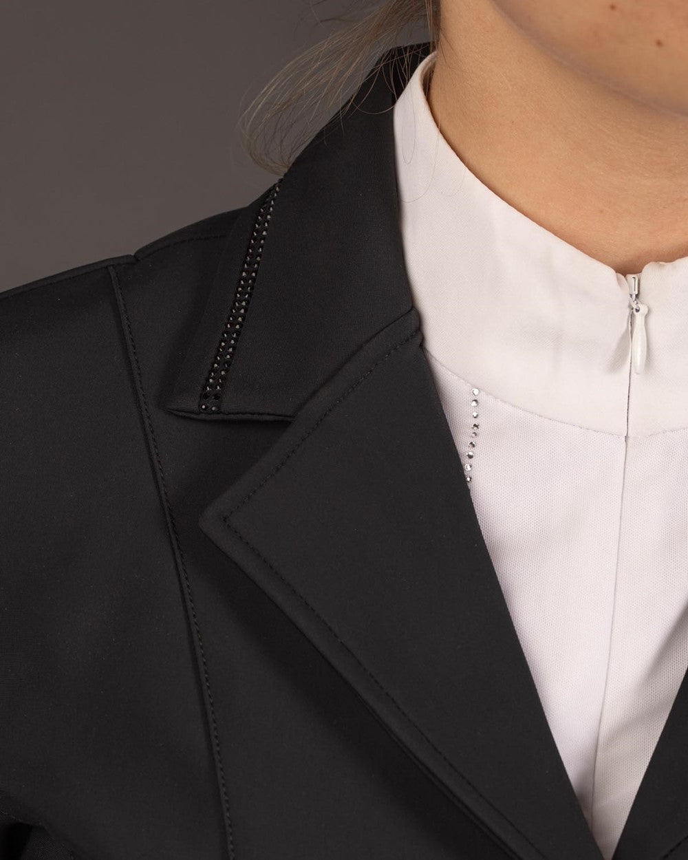 Eine detaillierte Nahaufnahme der schwarzen Turnierjacke zeigt den Kragen, der zweireihig mit schwarzen Kristallsteinen besetzt ist und dem Onyx-Turnierjacket seinen namensgebenden, edlen Glitzer verleiht.