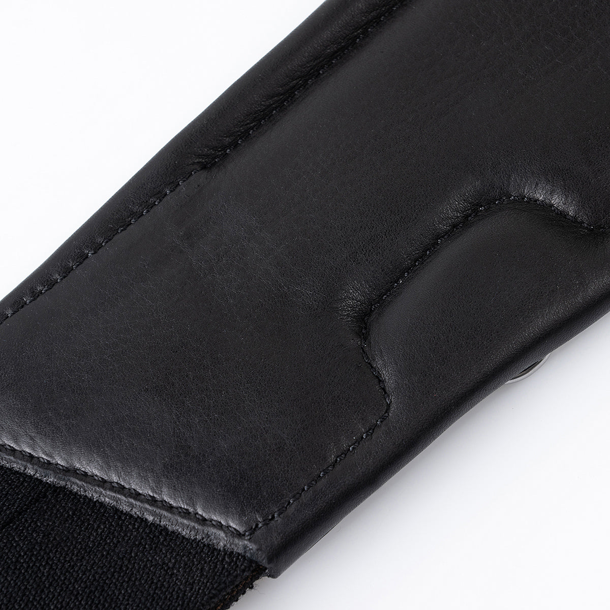 Detailansicht der weich gepolsterten Unterseite des schwarzen Winderen-Pressure-Relief-Sattelgurtes mit kleinem Bauchlatz. Der anatomische Ellbogenausschnitt aus geschmeidig unterlegtem Vollnarbenleder verhindert Scheuerstellen im Gurtbereich und bietet maximale Ellenbogenfreiheit sowie gezielte Druckentlastung für empfindliche Pferde.
