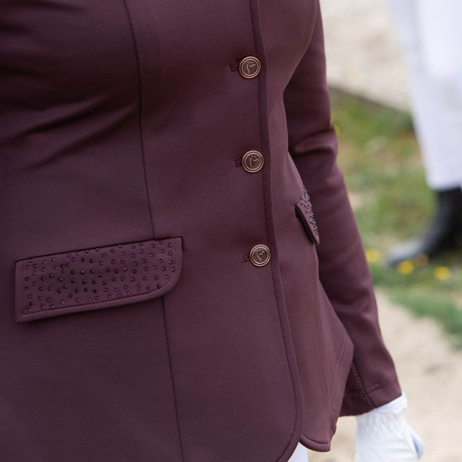 Detailaufnahme der Klappentaschen mit Glitzerapplikationen auf der Oberseite und der vier runden Frontknöpfe in Roségold des Harry’s Horse Turnierjackets Crystal in Bordeaux. Die klassische Turnierjacke überzeugt durch elegante, dezente Glitzerdetails und hochwertige Verarbeitung, perfekt für Damen Turnierkleidung und Dressurreiterinnen.