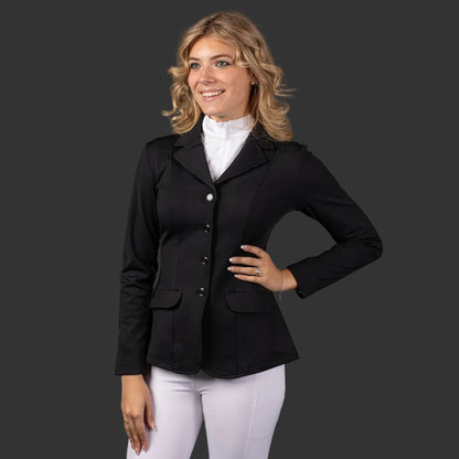 Eine Reiterin trägt das schwarze Turnierjacket „Sparkle“ von Harrys Horse in Schwarz mit Glitzerpaspelierung. Das Turnierjacket ist mit einem weißen Turniershirt und einer weißen Turnierreithose kombiniert. Das Turniersakko ist tailliert und mit einer dezenten Glitzerpaspelierung an den Taschen und dem Kragen versehen. Diese Details veredeln die Turnierreitbekleidung für Damen.