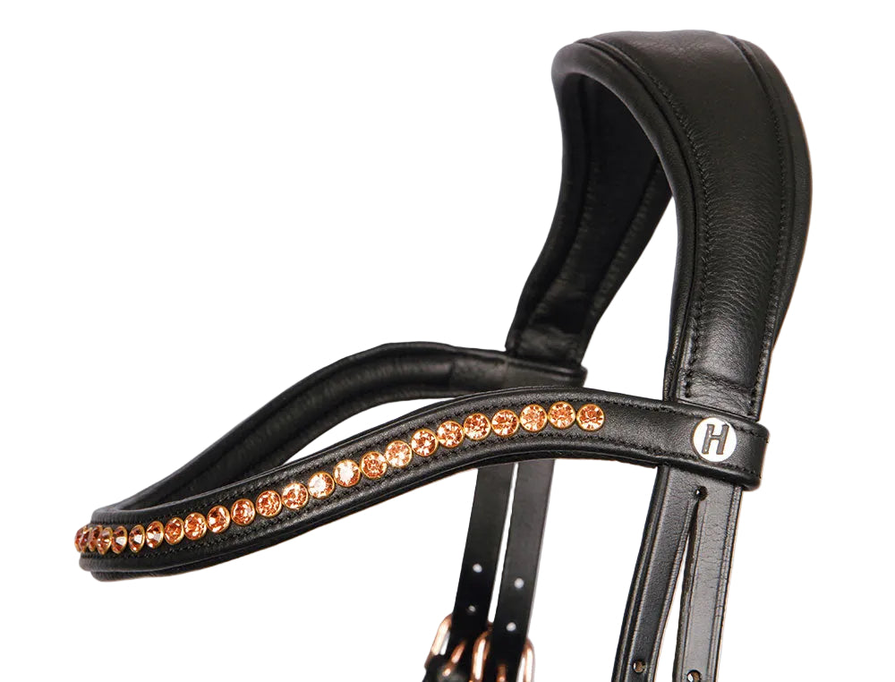 Geschwungenes Stirnband der Harry’s Horse Trense Rosegold Anatomic mit funkelnden Kristallsteinen in Roségold – elegante anatomische Trense in Schwarz. Anatomisch geformtes und extra weich gepolstertes Genickstück der Harry’s Horse Trense Rosegold Anatomic – ermöglicht freies Ohrenspiel und reduziert Druck auf empfindliche Nerven.