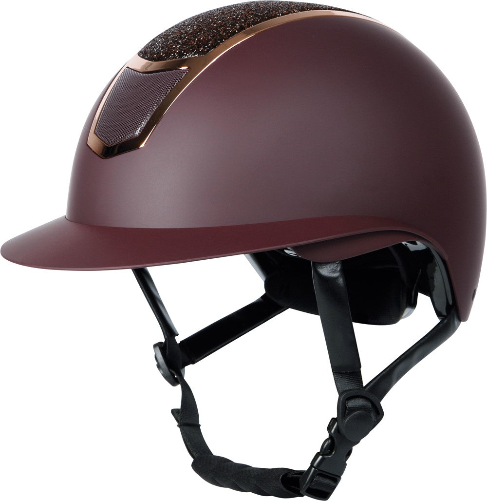 Der Harry’s Horse Sicherheitsreithelm Mont Blanc Sparkle in bordeaux rosegold zeigt in der seitlichen Ansicht von vorne das elegante Design mit matter Helmschale, rosegoldenen Akzenten und glitzerndem Frontbereich, ideal als moderner Glitzerreithelm für Turnier und Freizeit.