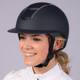 Reiterin trägt den Harry’s Horse Mont Blanc Sparkle Sicherheitsreithelm in navy silber mit blauem Glitzer und silbernen Akzenten, Helmverschluss verschlossen, perfekt an den Kopf angepasst, moderner Glitzerreithelm für Freizeit- und Turnierreiterinnen mit elegantem Design und sicherer Funktionalität. Das große Helmvisier wirkt sehr edel.