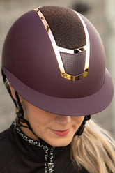 Reiterin trägt den Harry’s Horse Mont Blanc Sparkle Reithelm in Bordeaux Schwarz Rosegold, vordere Front mit funkelndem Glitzer, rosegold-glänzende Metalleinsätze und integrierte Belüftung für optimalen Komfort beim Reiten, passend zum schwarzen Turniershirt.