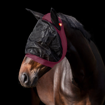 Ein Pferd trägt die Imperial Riding Fliegenmaske IRH Careful in Bordeaux, die durch ihre sehr gute Passform eng am Kopf anliegt, Insekten zuverlässig fernhält und dem Pferd ein entspanntes und zufriedenes Erscheinungsbild auf der Weide oder im Alltag ermöglicht. Das Pferd kann die Fliegenmaske nicht abstreifen oder verlieren. Material drückt nicht auf die Augen, sondern umhüllt diese mit Abstand! 