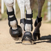 LeMieux Carbonite Springglocken Schwarz am Pferdebein im Einsatz beim Springen, geeignet für Training, Stangenarbeit, Gelände und Parcours mit schneller Beinarbeit.