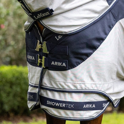 Detailansicht des innovativen Brustverschlusses der LeMieux Arika Shower-Tek Fliegendecke mit um 45 Grad abgewinkelten T-Stegen zur gleichmäßigen Druckverteilung auf die Pferdeschulter sowie der robusten Klettverschlüsse des abnehmbaren Halsteils, die ein flexibles Deckenmanagement und eine einfache Handhabung bei wechselhaftem Wetter ermöglichen.