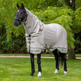 Ein edler Rappe trägt die LeMieux Arika Armour-Tek Fliegendecke in Stone, deren patentiertes zweiteiliges Saum-Design und tieferer Schnitt für eine druckfreie Passform und maximale Abdeckung des Pferdekörpers sorgen. Das Material der Fliegendecke wirkt leicht und dünn. Perfekt für warme Sommer.