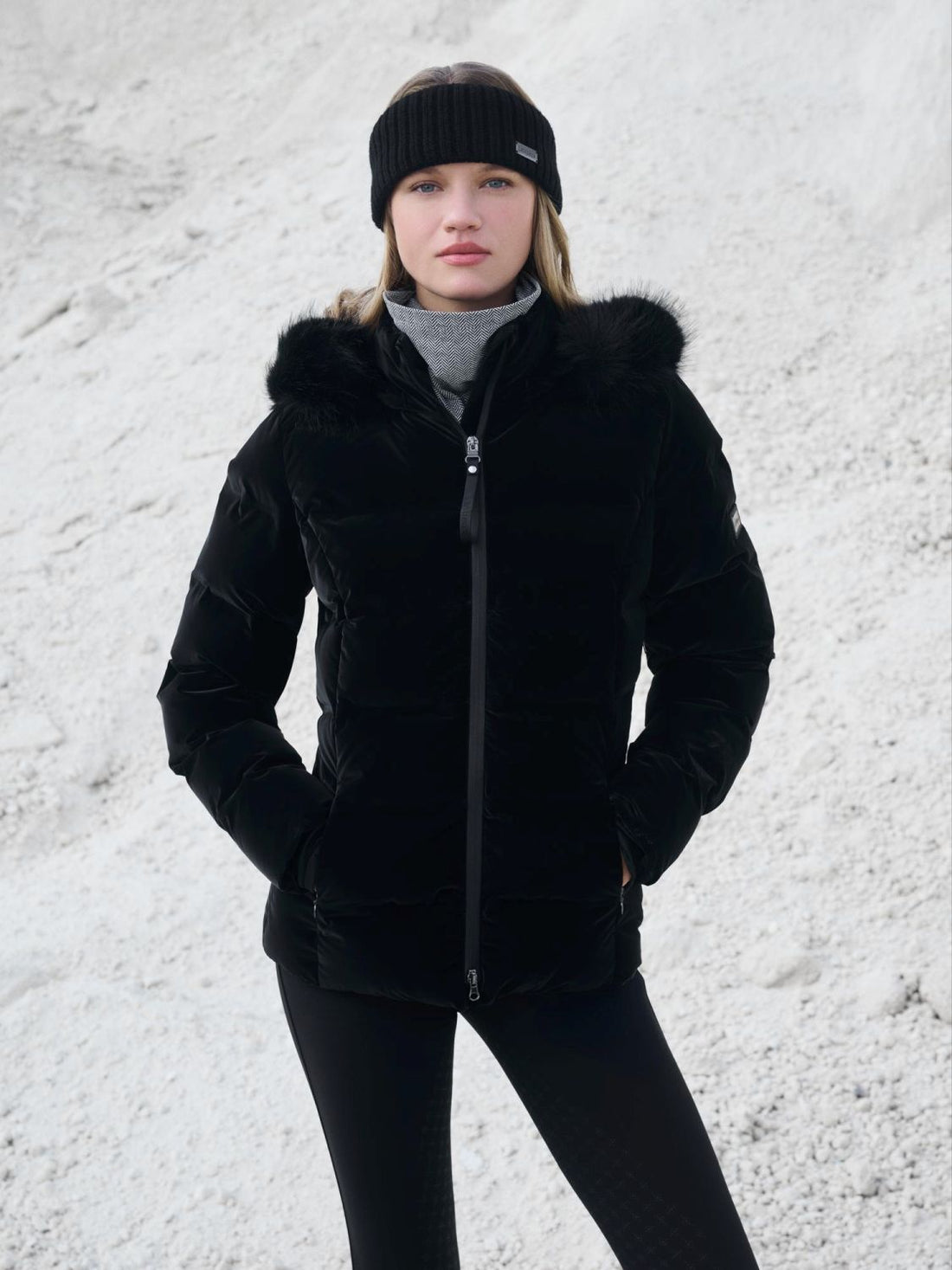 Model trägt die Steppjacke aus der LeMieux Kollektion Aspen kombiniert mit dem Headband Aspen und dem Schlauchschal Snood Aspen Herringbone zu einer schwarzen LeMieux Reithose.