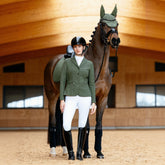 Detailgetreuer Farbabgleich: Das LeMieux Turnierjacket Jessica Mesh und die Essence Schabracke im identischen Farbton Pine Green. Reiterin steht links neben dem Pferd und präsentiert das perfekt abgestimmte LeMieux Set in harmonischem Dunkelgrün.