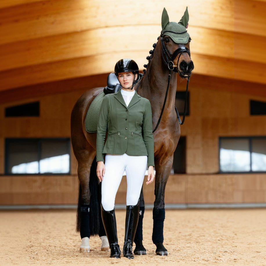 Detailgetreuer Farbabgleich: Das LeMieux Turnierjacket Jessica Mesh und die Essence Schabracke im identischen Farbton Pine Green. Reiterin steht links neben dem Pferd und präsentiert das perfekt abgestimmte LeMieux Set in harmonischem Dunkelgrün.