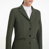 Nahaufnahme des LeMieux Turnierjacket Jessica Mesh in Pine Green: Fokus auf die edlen Logo-Knöpfe, den perforierten Mesheinsatz zur Luftzirkulation unter den Armen und die praktischen Reißverschlusstaschen für das Turnier.