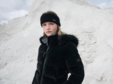 Reiterin trägt LeMieux Stirnband Aspen Schwarz mit Aspen Puffer Jacket und dem Aspen Herringbone Schlauschal – stilvolles Winteroutfit für Reitsport.