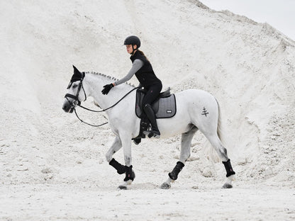 Reiterin und Pferd im eleganten Partnerlook mit LeMieux Aspen Dressage Square Herringbone schwarz weiß Schabracke, modische Capsule Collection, stilvolle Dressurausrüstung.