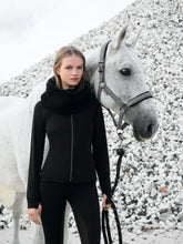 Weißes Pferd mit LeMieux Halfter Aspen Herringbone schwarz weiß, Reiterin in Lemieux Aspen Capsule Collection, elegantes Pferdehalfter mit Fischgrätmuster im Outdoor-Einsatz.