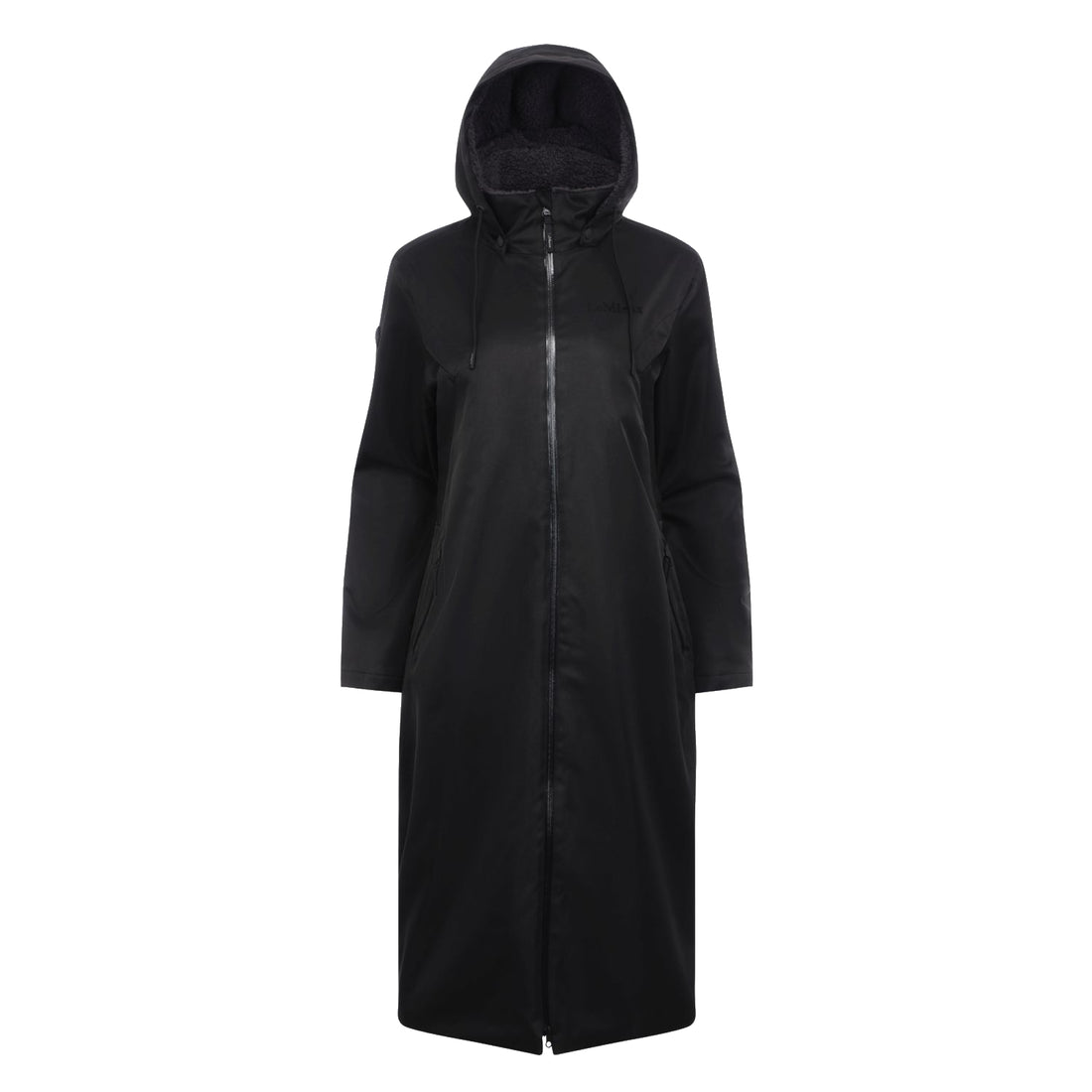Langer und weiter schwarzer Reitmantel für Damen in Vorderansicht. Mit gefütterter Kapuze, mit schwarzem kuscheligem Fleece. Der lange Reißverschluss glänzt durch die wasserdichten verklebten Nähte.