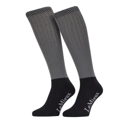 LeMieux Reitstrümpfe Aspen Herringbone Black – elegante Kniestrümpfe mit schwarz-weißem Fischgrätmuster aus der Aspen Kollektion. Kombinierbar mit schwarzen Reithosen und anderen Kleidungsteilen der Aspen Kollektion.