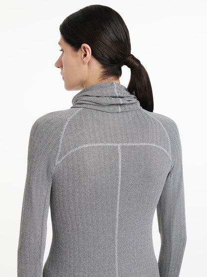 Der LeMieux Snood Aspen Herringbone mit Fischgrätmuster wird hier in Rückansicht von dem Model kombiniert mit dem Aspen Herringbone Base Layer von Lemieux getragen. Das Fischgrätmuster des Schlauchschals geht in das des Base Layers über. Perfekte Kombination.