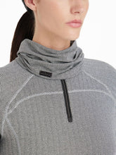 Der LeMieux Snood Aspen Herringbone mit Fischgrätmuster wird von dem Model kombiniert mit dem Aspen Herringbone Base Layer von Lemieux getragen. Der leichte Schlauchschal liegt locker um den Hals.Das Fischgrätmuster erinnert an die Gräten eines Fisches.