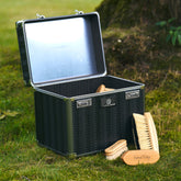 Geöffnete Imperial Riding Putzbox IRHShiny grey black im Außenbereich vor Stall oder Pferdekoppel, mit sichtbarem Spiegel im Deckel, geriffelter schwarzer Wellenstruktur, Zahlenschloss und schwarz glitzerndem Imperial Riding Logo, umgeben von Pferdepflegebürsten – funktionale Premium Putzbox für Stall und Turnier.