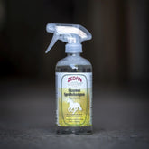 Eine Flasche ZEDAN Ekzemer-Sprühshampoo steht auf dem Boden in einem Pferdestall