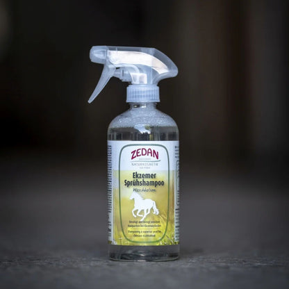 Eine Flasche ZEDAN Ekzemer-Sprühshampoo steht auf dem Boden in einem Pferdestall