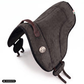Die Perspektivansicht von oben auf das dunkelgrau Brockamp Bareback Pad Reitpad Spezial zeigt die ergonomische Wildleder-Sitzfläche, rahmende Pauschen sowie die seitliche V-Gurtung. Die flexibel verschiebbaren Gurtpolster mit rutschfestem Neopren veranschaulichen die gleichmäßige Druckverteilung beim Reiten ohne Sattel auf Pferd und Pony.