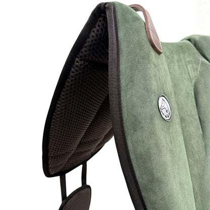 Die Detailaufnahme des grünen Brockamp Bareback Pad Reitpad Spezial zeigt das Reitkissen von vorne mit Blick auf die strukturierte, rutschfeste Anti-Slip-Unterseite aus Neopren im Übergang zur feinen Wildleder-Oberfläche. Erkennbar sind das runde Brockamp-Logo-Emblem, der braune Ledergriff mit Kontrastnaht und die robuste Kantenverarbeitung für optimalen Halt beim Reiten ohne Sattel.
