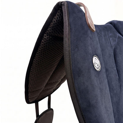 Die Detailaufnahme des marineblauen Brockamp Bareback Pad Reitpad Spezial zeigt das Reitkissen von vorne mit Blick auf die strukturierte, rutschfeste Anti-Slip-Unterseite aus Neopren im Übergang zur feinen Wildleder-Oberfläche. Erkennbar sind das runde Brockamp-Logo-Emblem, der braune Ledergriff mit Kontrastnaht und die robuste Kantenverarbeitung für optimalen Halt beim Reiten ohne Sattel.