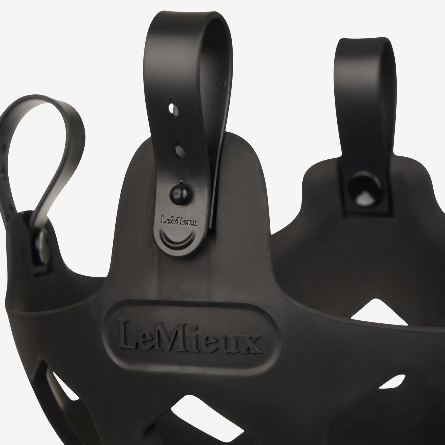 Hochauflösendes Produktdetail des schwarzen LeMieux Weidemaulkorbs Noma. Gezeigt wird die geschlossene Schlaufe mit Pin im ausgewählten Loch. Zum schnellen Öffnen und einfachen Abnehmen der Fressbremse direkt am Pferd wird die Schlaufe unkompliziert vom Pin weggezogen.