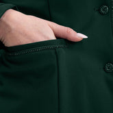 Detailaufnahme der rechten Einschubtasche des Harcour Damen Reitjackets Oria in Jungle. Eine Turnierreiterin schiebt ihre Handspitze in die praktische Tasche, welche edel mit funkelnder Glitzerlitze verziert ist. Durch diese sich wiederholenden Glitzer- und Designelemente entsteht ein harmonisches Gesamtbild der exklusiven Harcour Turnierbekleidung. Ein funktionales und zugleich stilvolles Turniersakko für Frauen, die auf dem Turnierplatz Wert auf durchdachte Details legen.