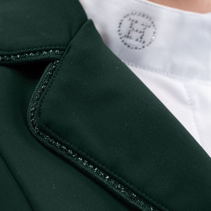 Hochauflösende Detailaufnahme der rechten Kragenseite des Harcour Damen Turnierjackets Oria in Jungle. Die elegant abgerundeten Kragenkanten und die rahmende Glitzerlitze am Kragenrand harmonieren perfekt mit dem weichen, leichten Material der Turnierreitjacke. Diese verspielten Design-Details machen die funktionale Harcour Turnierkleidung zum echten Blickfang. Ideal einsetzbar als exklusives Allround-Turniersakko, edles Dressurjacket oder funktionales Springturnierjacket für Frauen.