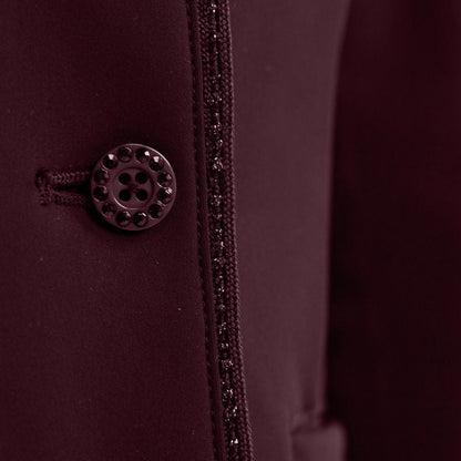 Detailaufnahme der Vorderseite mit dem edlen Knopfverschluss der Harcour Damen Turnierreitjacke Oria in Aubergine. Das Bild zeigt das harmonische Zusammenspiel der mit Kristallsteinen veredelten Knöpfe und der funkelnden Glitzerlitze, die das Reitsakko vom Kragen bis zum Saum rahmt. Diese hochwertige Verarbeitung der sichtbaren Knöpfe über dem Double-Closure-System ist eine Besonderheit der Turnierbekleidung für Reiterinnen, die ein exklusives und individuelles Turnieroutfit suchen.