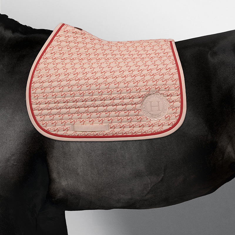 Sportliche Harcour Jump Schabracke Karembar Jump Shell Grapefruit auf schwarzem Rappen. Der helle Beigeton Shell leuchtet auf dem schwarzen Kurzhaar. Perfekte Lage unter dem Springsattel beim Ausritt oder Training. Mit Waffelstruktur-Innenfutter für schnelle Trocknung.